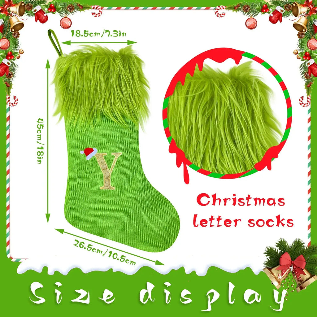 Green knitted christmas stocking with fluffy faux fur cuff and gold embroidered letter y topped with small red santa hat
