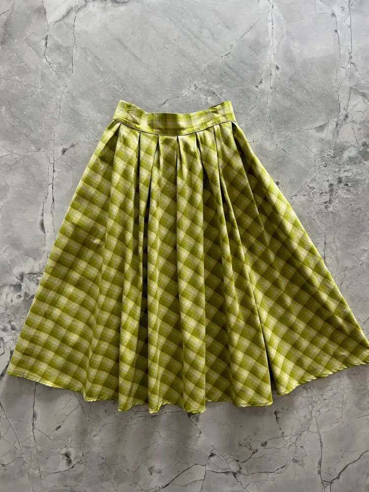 Green plaid Doris cotton a-line skirt with pockets featuring a flared olive green and cream checkered design and pleated waistband