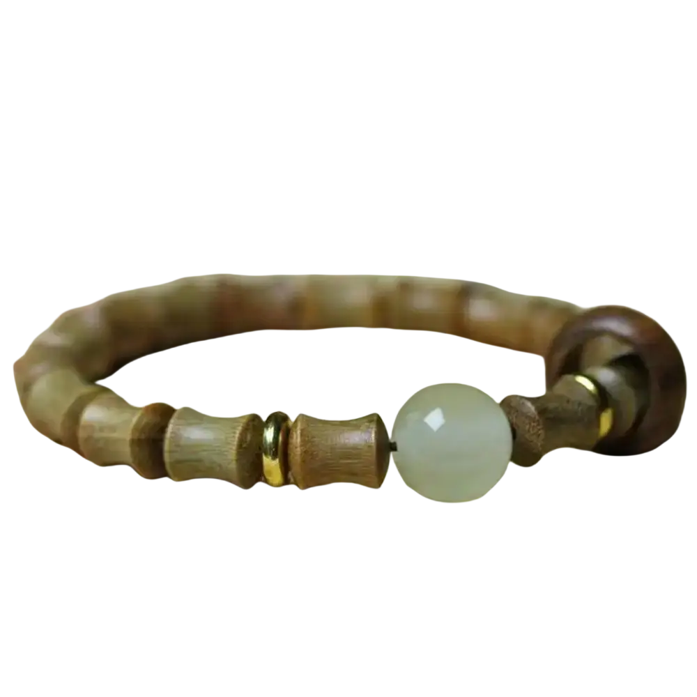 A delicate green sandalwood hand bracelet with light brown wood beads and a pale green jade bead with gold spacers