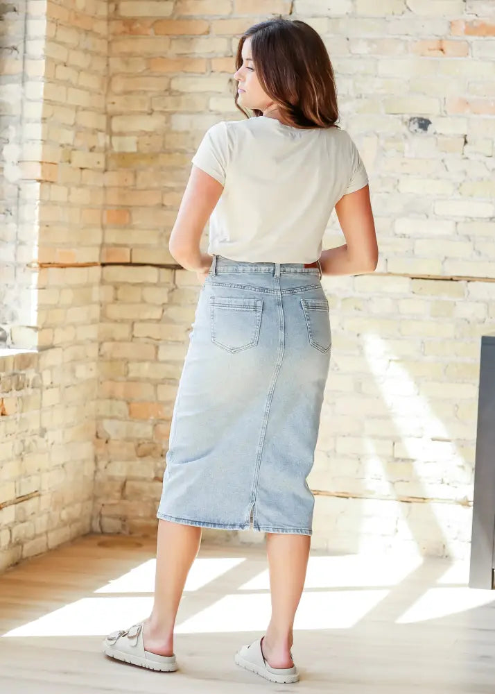 Back side of greta light wash button front denim midi skirt with straight cut and back pockets in light-wash denim