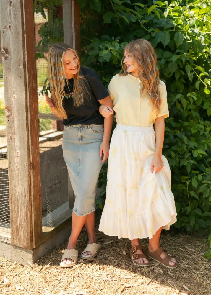 Greta light wash button front denim midi skirt with flowing off-white fabric and subtle yellow floral pattern high waistline