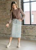 Light blue denim midi skirt with a front seam and button closure in a light wash material