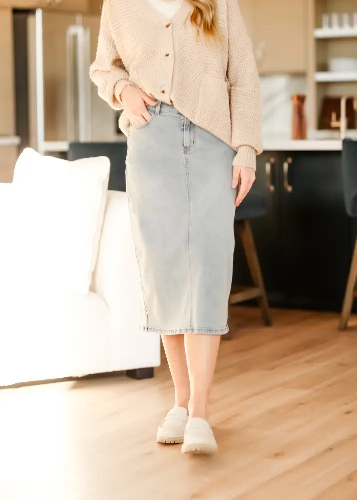 Greta light wash button front denim midi skirt with straight cut and visible stitching along front seam