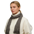 A soft textured gray acrylic skinny scarf with fringed ends worn as a lightweight winter accessory