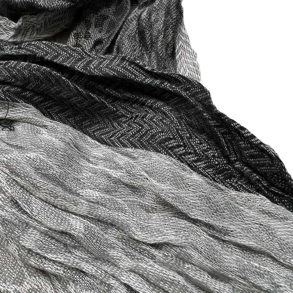 A soft grey jacquard polyester winter long scarf for women with a textured black and gray herringbone pattern