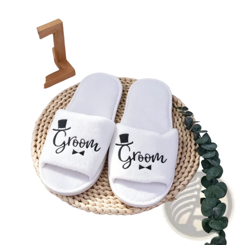 White plush slip-on groom slide slippers with black text and top hat and bow tie design for wedding party footwear