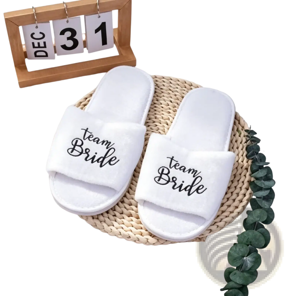 White team bride slide sandals with black cursive lettering designed as wedding party footwear for grooms