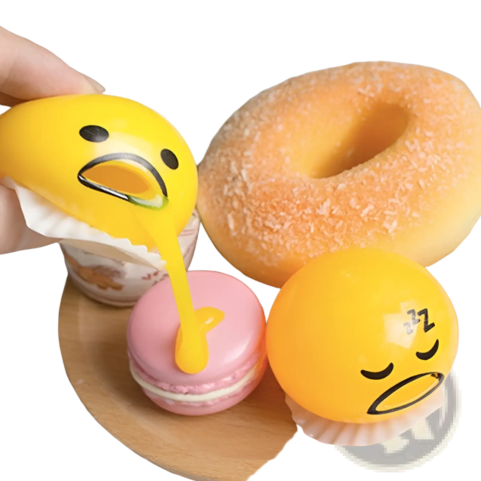 Yellow gudetama-themed squishy stress relief toy with glossy finish vomiting yellow liquid onto pink macaron