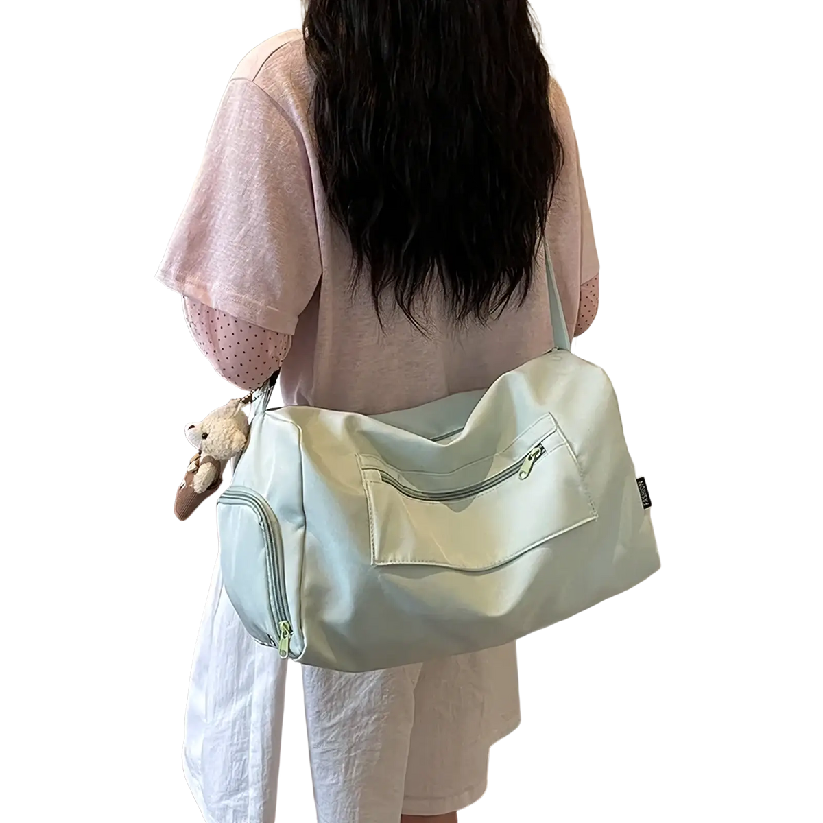 A soft mint green canvas gym duffle bag with a front zippered pocket and a plush toy attached on the side