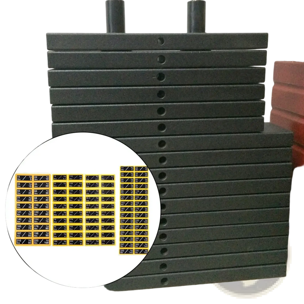 Stack of black rubber weight plates with yellow and black dual unit fitness stack labels for gym use