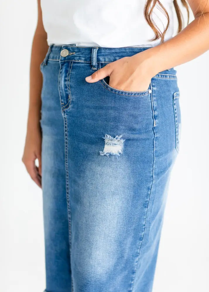 Blue denim Hadley high rise distressed midi skirt featuring a thigh distressed patch on the front side