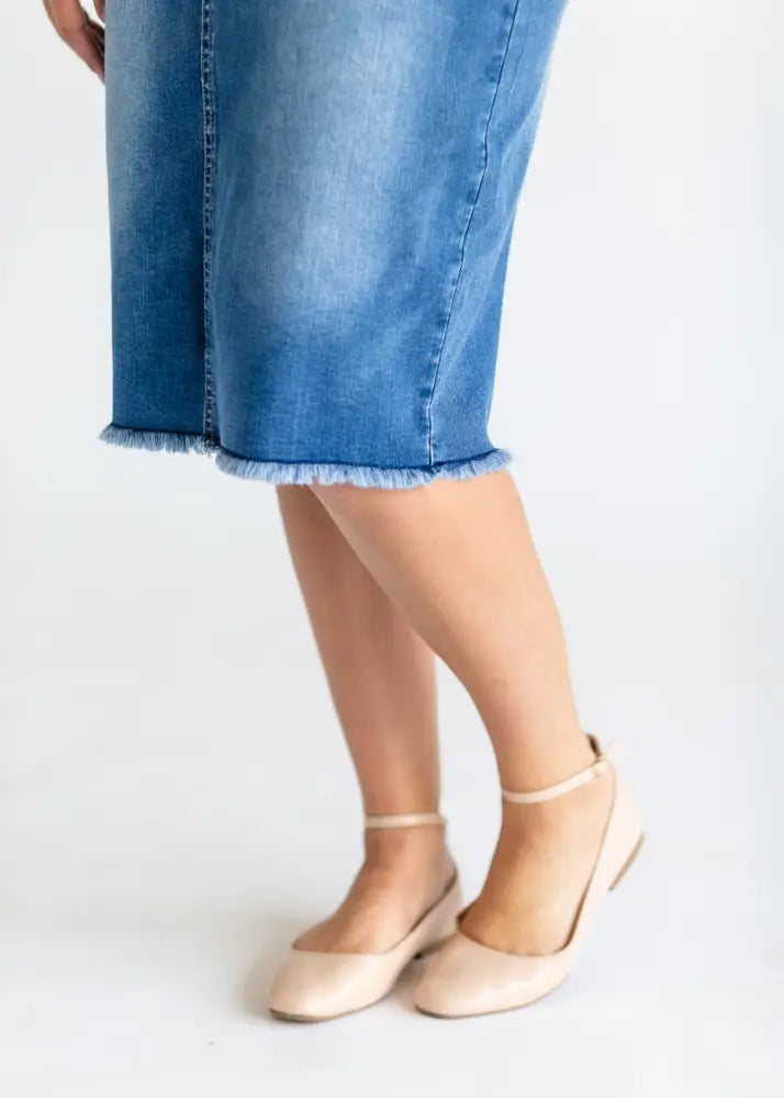 Hadley high rise distressed denim midi skirt in blue with frayed hem and visible stitching along the side seam