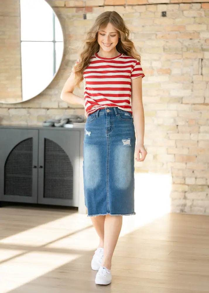 Hadley high rise distressed blue denim midi skirt featuring frayed hem and ripped patches in classic jean material
