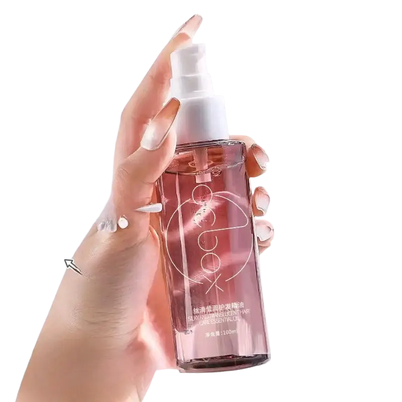A transparent pink glass bottle of koco hair care essential oil 100ml with white spray nozzle for dry hair