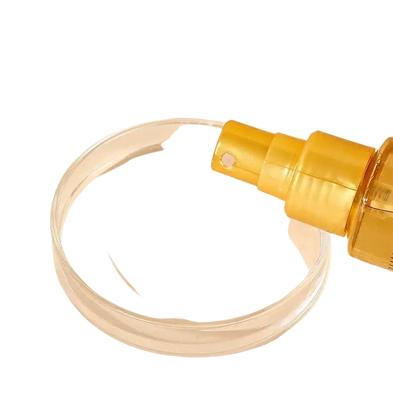 Golden hair care essential oil spray bottle with sleek ribbed nozzle and transparent body for luster and repair