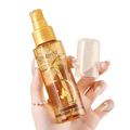 Golden hair care essential oil spray of ouzhini with transparent amber body and gold accents for luster and repair