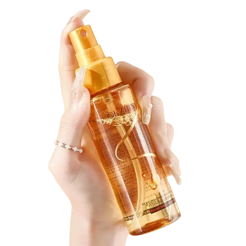 Golden spray bottle of ouzhin perfumed hair care essential oil with transparent body and ornate gold lettering for luster and repair