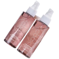 Two translucent rose-gold spray bottles with white caps featuring minimalist silver logos for hair care nourishing repair formula