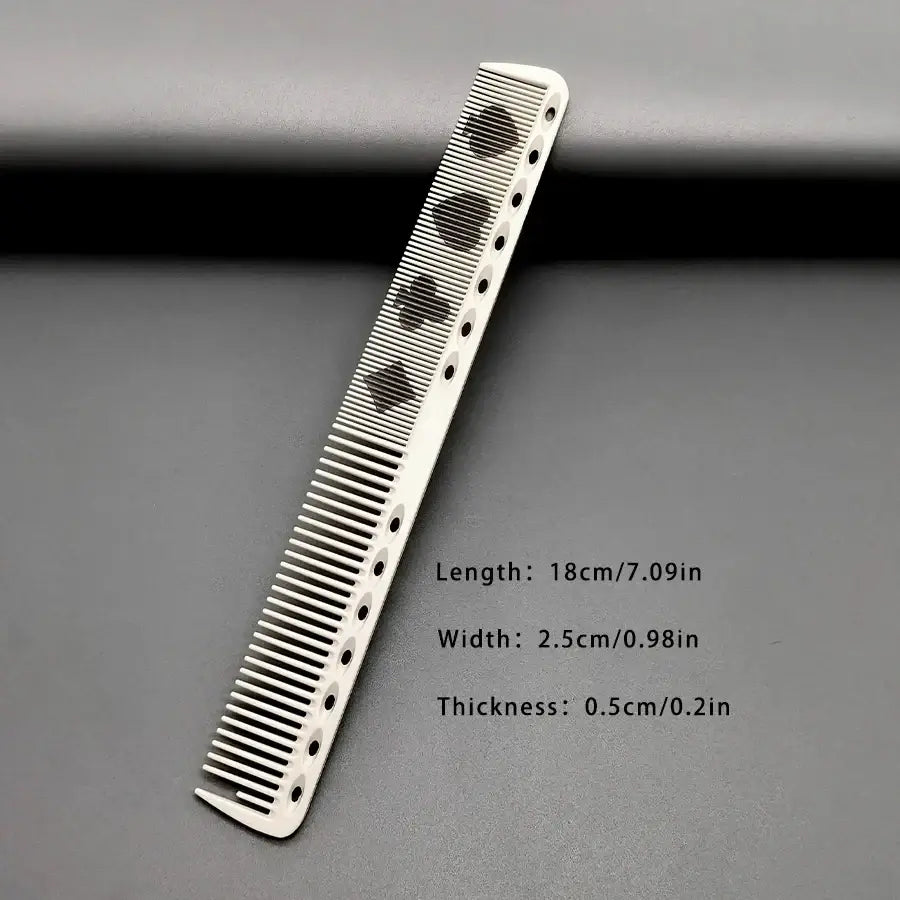 White resin hair cutting comb with black spade designs and evenly spaced holes for precise styling use