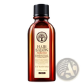A sleek amber glass bottle with black ribbed cap labeled hair salon perfect first essential by Lakou hair essential oil