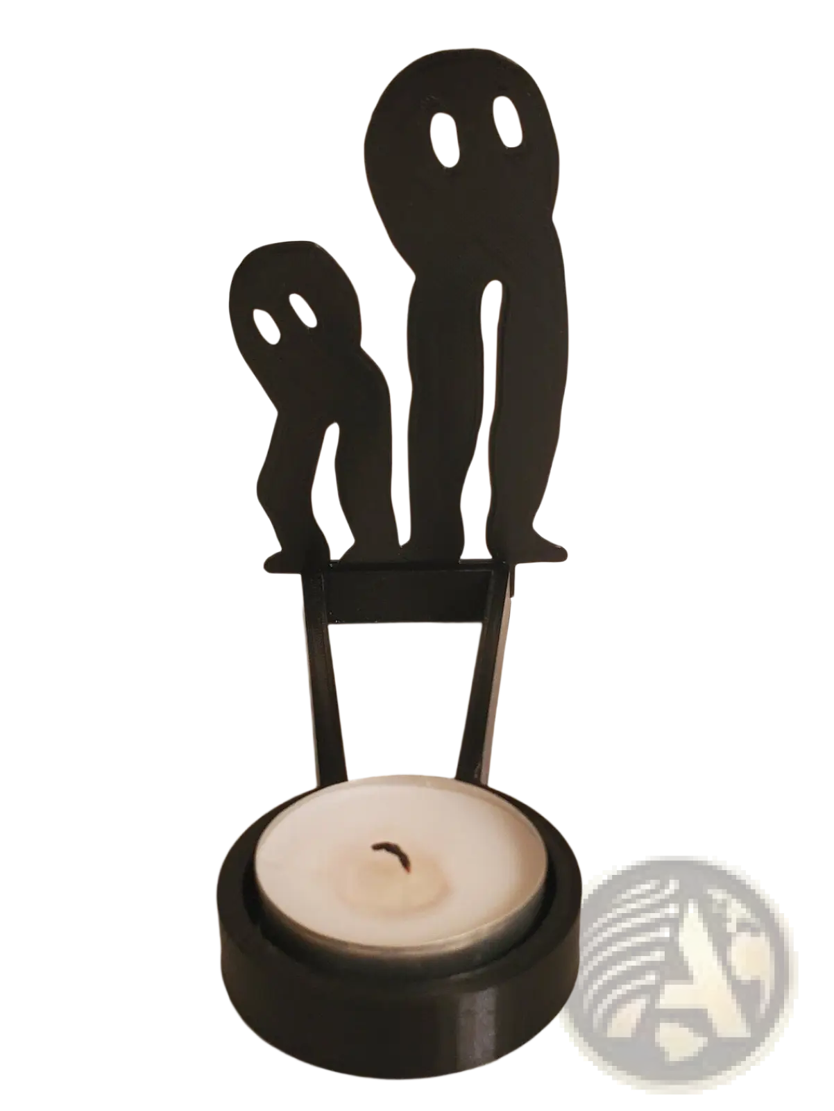 Black metal ghost-shaped candle holder with circular base holding a white tea light for halloween decor