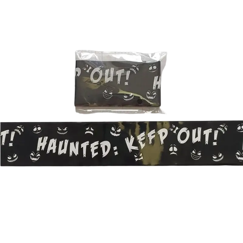 Black halloween caution tape with white spooky faces and haunted keep out text for party warning barrier