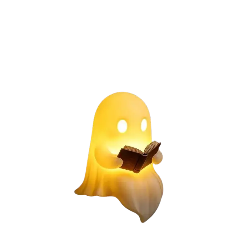 A glowing yellow halloween desktop luminous ghost lamp with illuminated eyes holding a small book for reading use