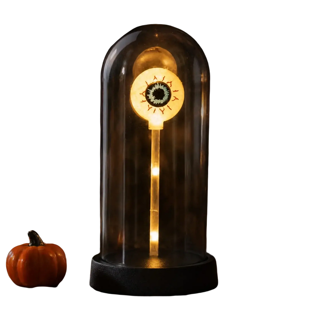 A glowing halloween lights decorations eye lamp with warm yellow illumination inside a clear glass dome