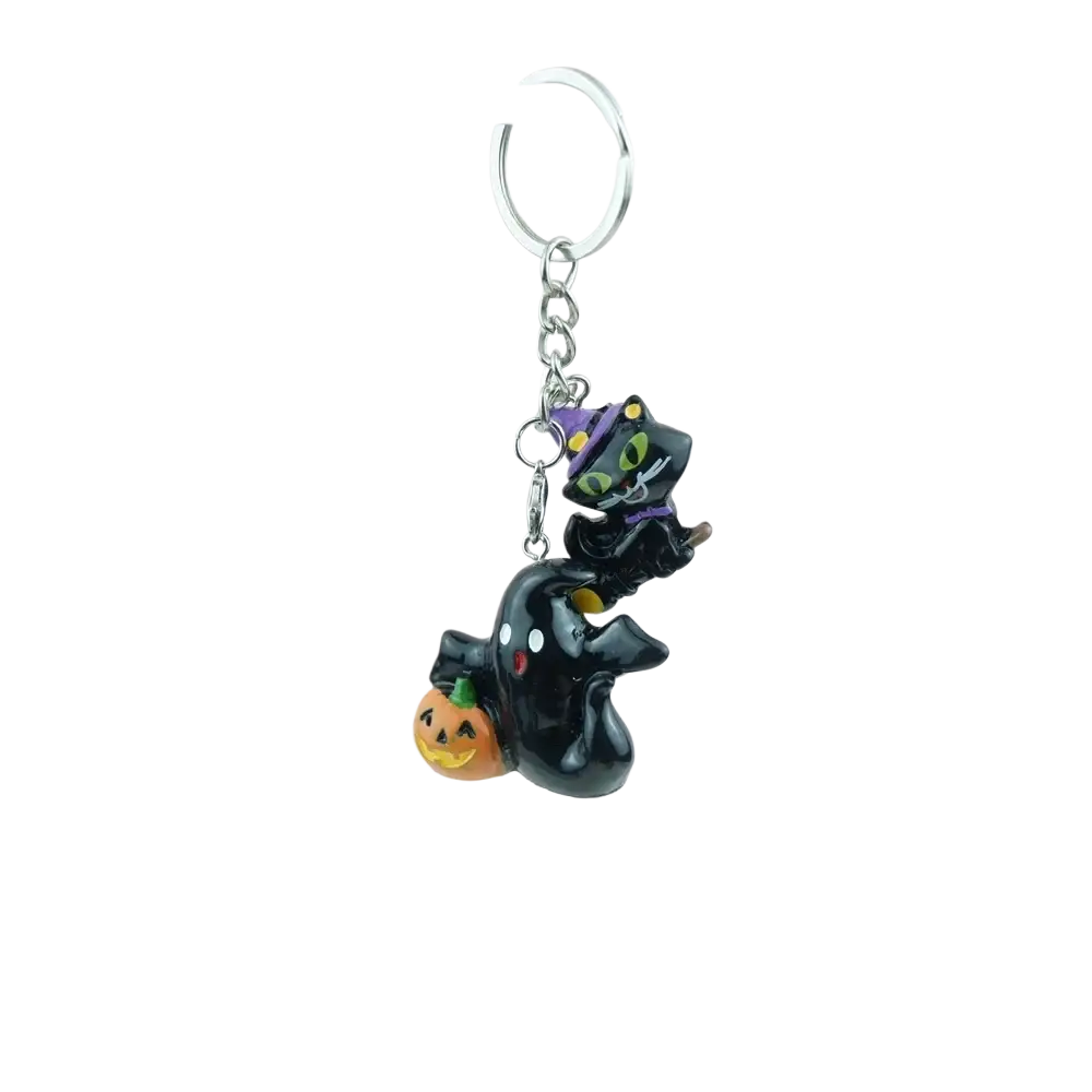 Handmade resin halloween pumpkin keychain featuring a black cat with green eyes and purple witch hat on a black ghost figure