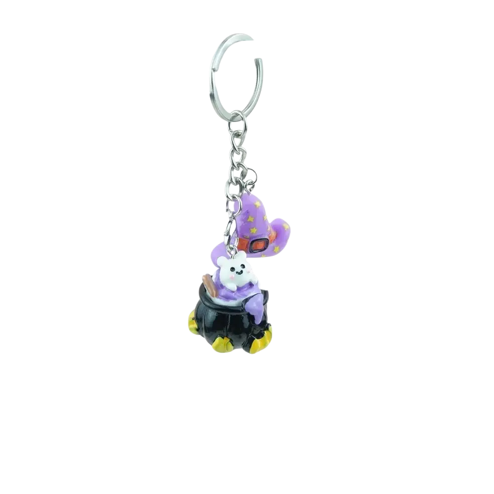 A handmade resin halloween pumpkin keychain featuring a white cat figurine in a purple witch hat inside a black cauldron