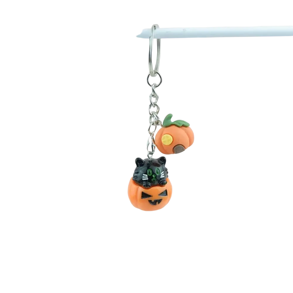 Halloween pumpkin keychain handmade resin jewelry featuring an orange pumpkin with a black cat and green eyes