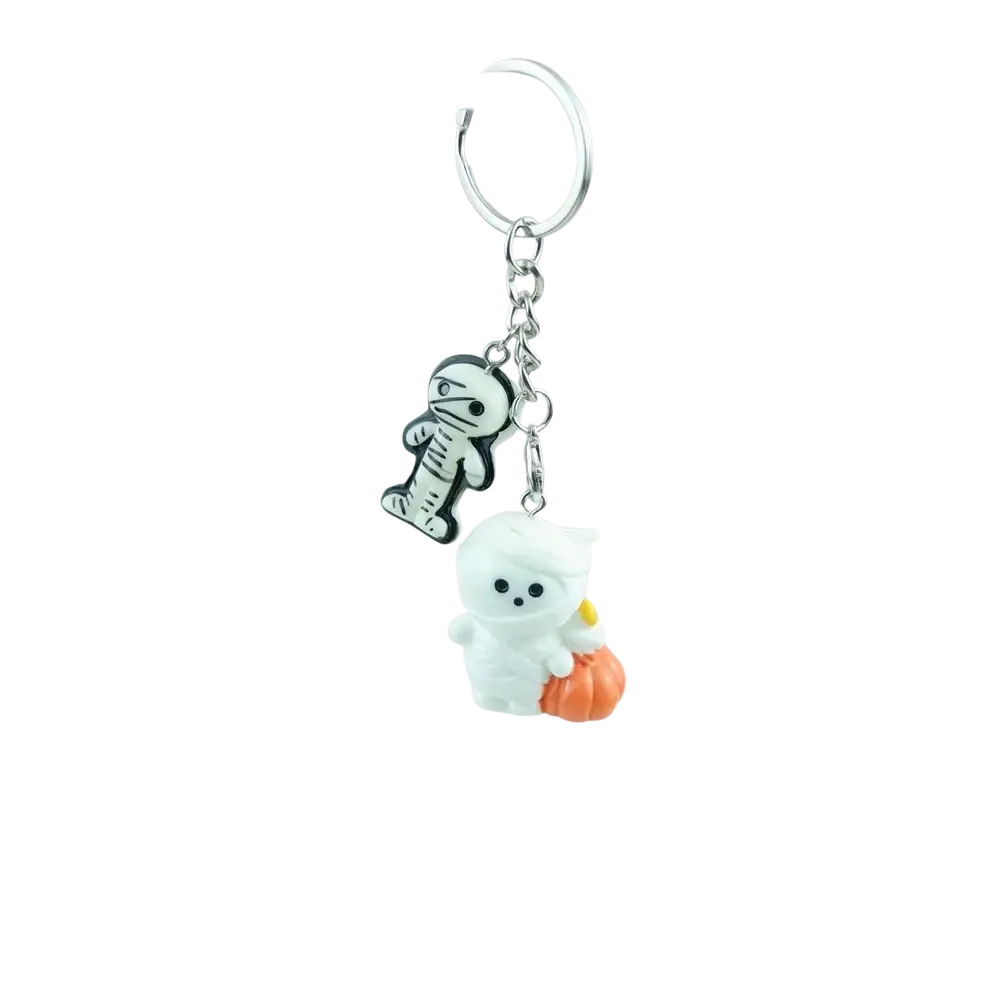 A silver-toned handmade resin Halloween pumpkin keychain with black and white mummy and ghost charms