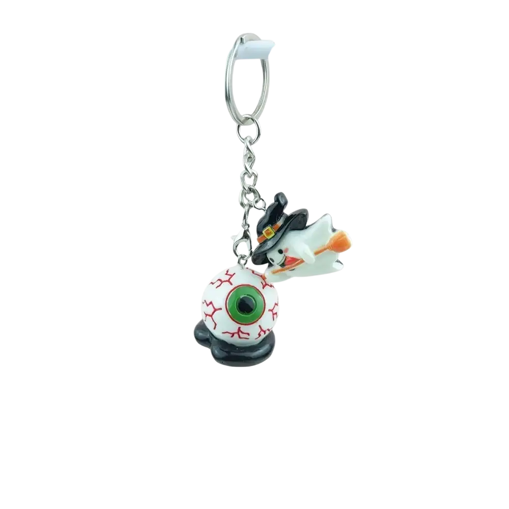Halloween pumpkin keychain handmade resin jewelry featuring a white ghost with black hair riding an orange broom atop a detailed eyeball charm
