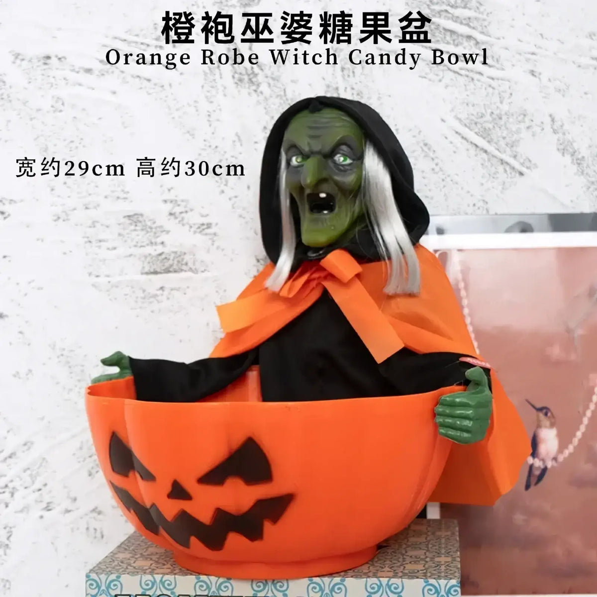 Orange pumpkin-shaped skeleton candy bowl with witch figure in orange robe and black hood made in mainland china