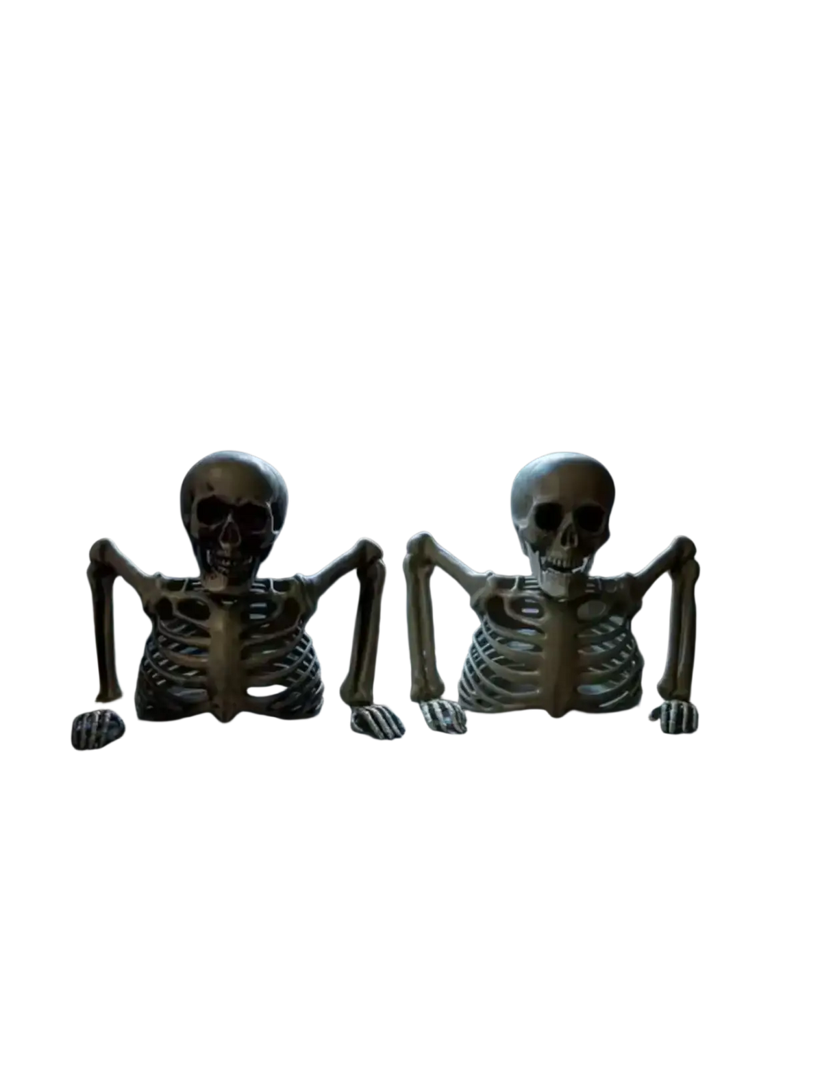 Two beige plastic skeleton props with articulated limbs sit on a stone windowsill for halloween indoor outdoor decor