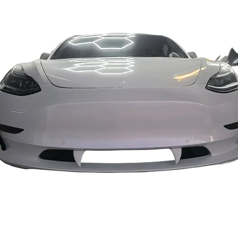 White Tesla Model 3 with glossy finish and distinctive front grille featuring Halloween vampire teeth plastic monster fangs decals