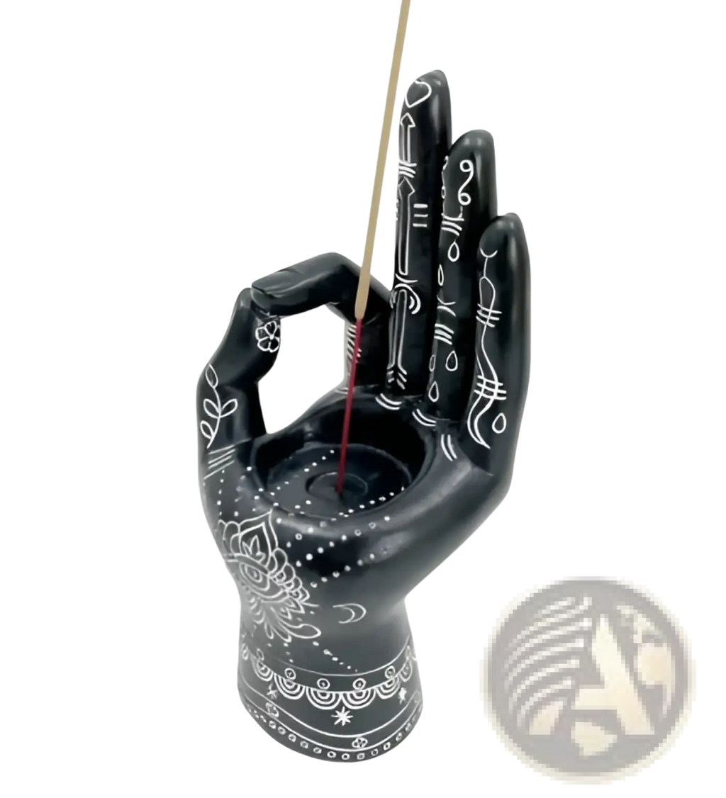 Black hamsa hand incense burner with intricate white floral patterns and central circular indentation for incense stick