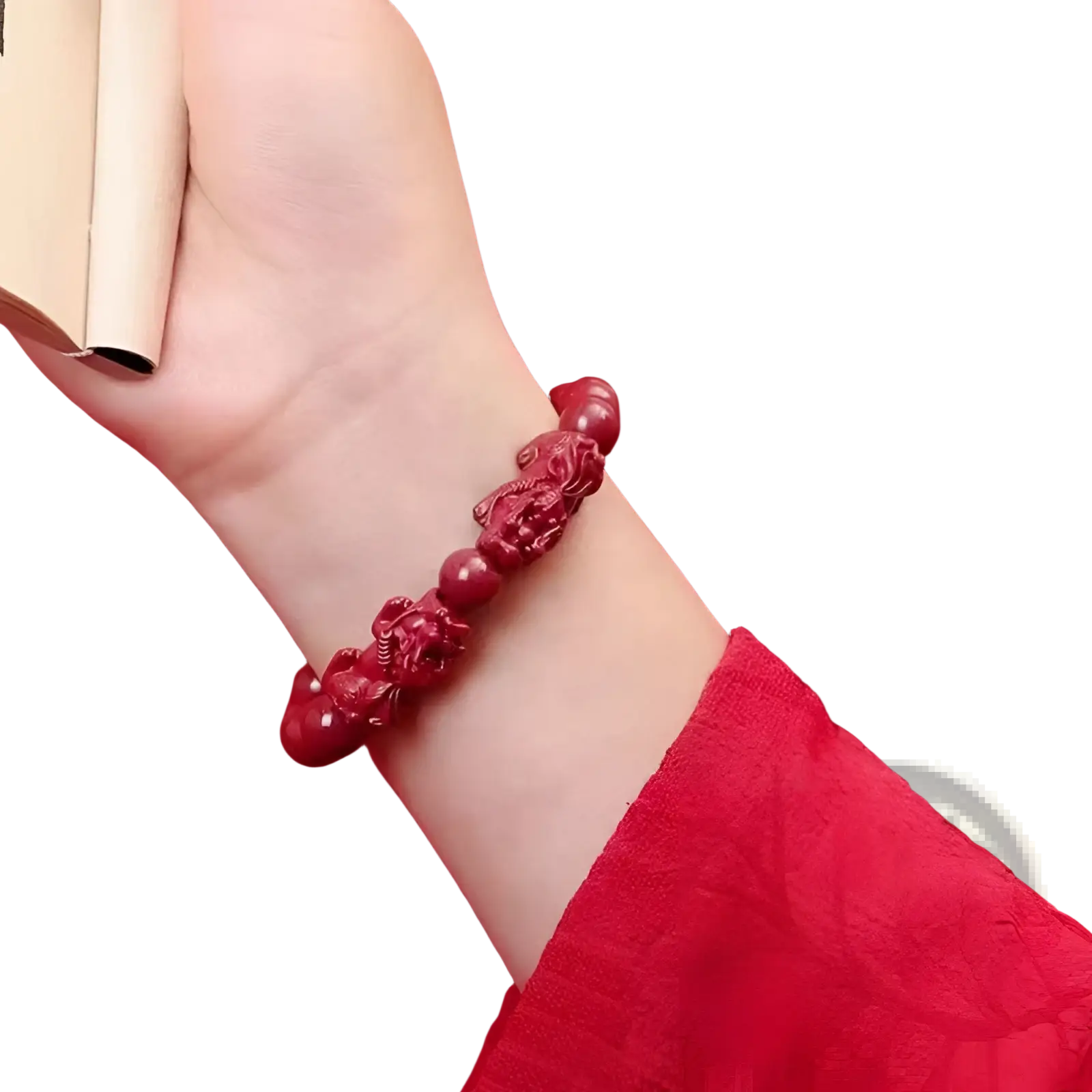 A vibrant red hand carved purple gold cinnabar double pixiu bracelet with smooth spherical beads worn on a wrist