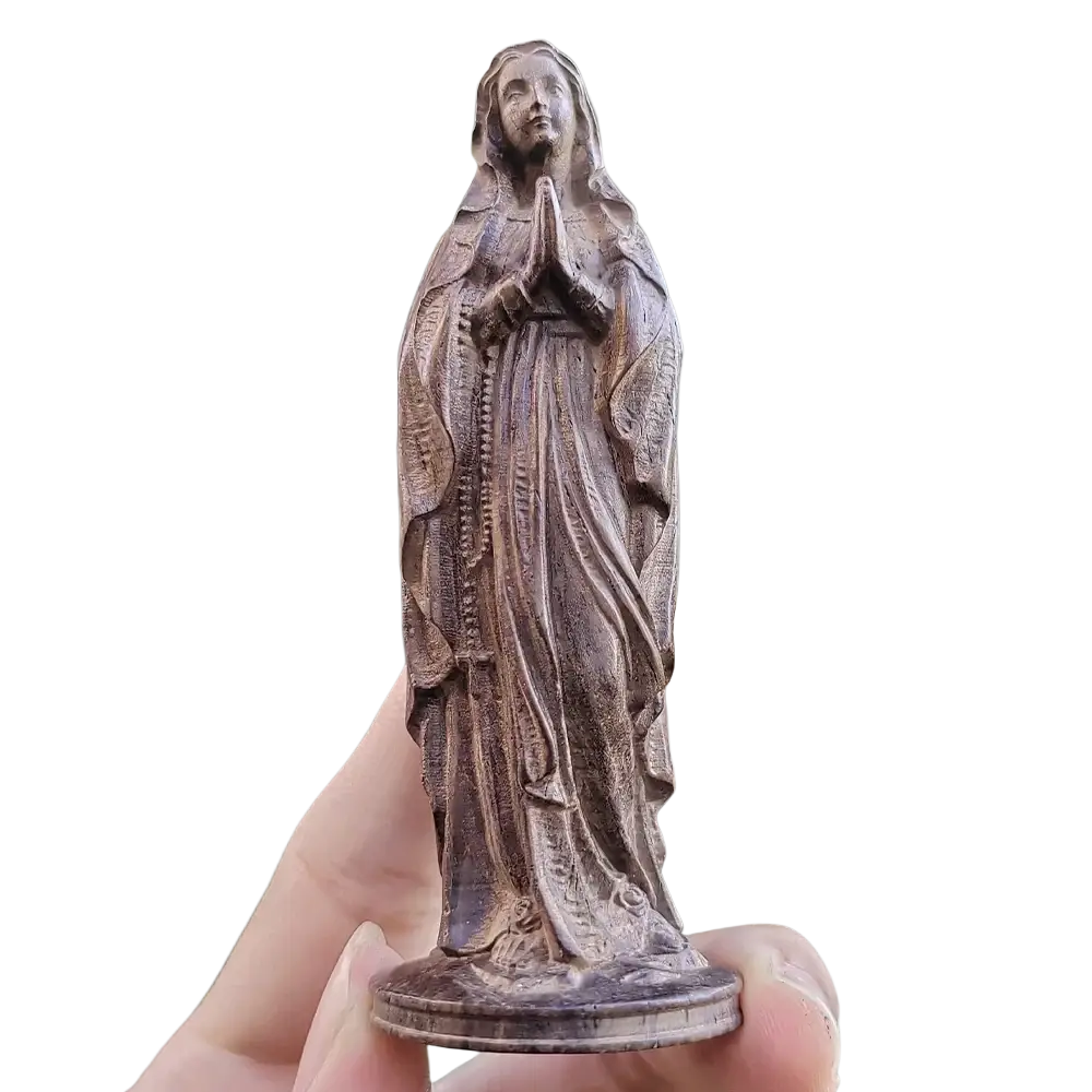 A bronze-colored hand carved wooden virgin mary figurine holding a rosary with intricate detailing