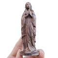 A bronze-colored hand carved wooden virgin mary figurine holding a rosary with intricate detailing