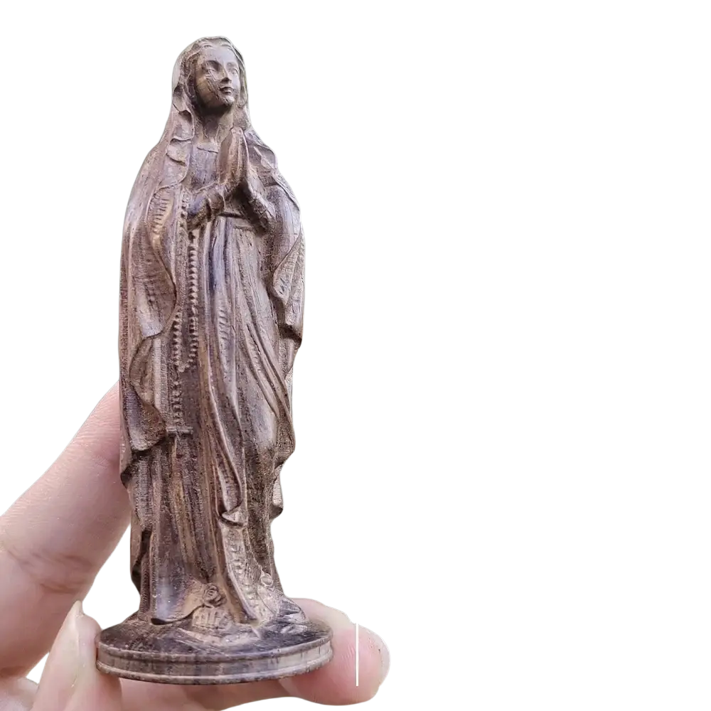 Hand carved wooden virgin mary figurine of a praying woman with flowing robes and a beaded necklace held in hand