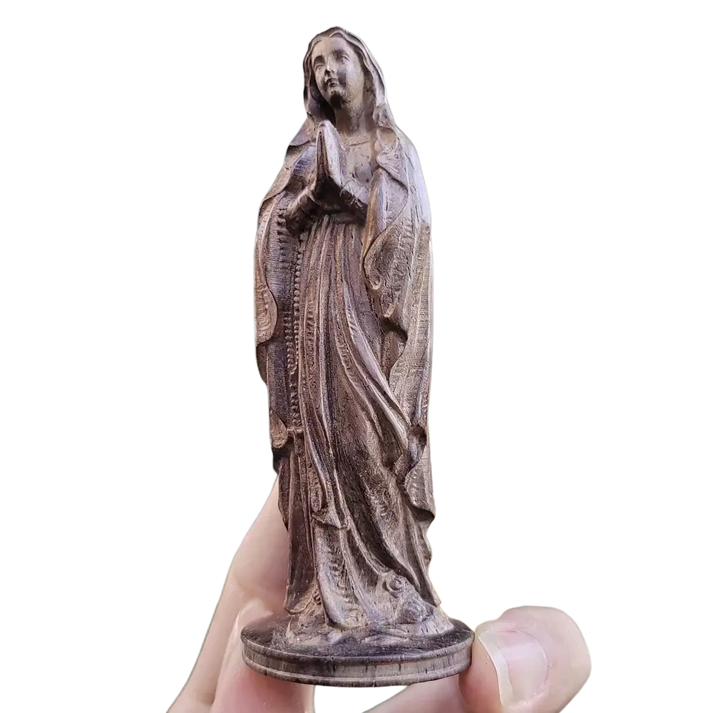 Hand carved wooden virgin mary figurine with intricate details flowing robes and serene expression in natural wood tone