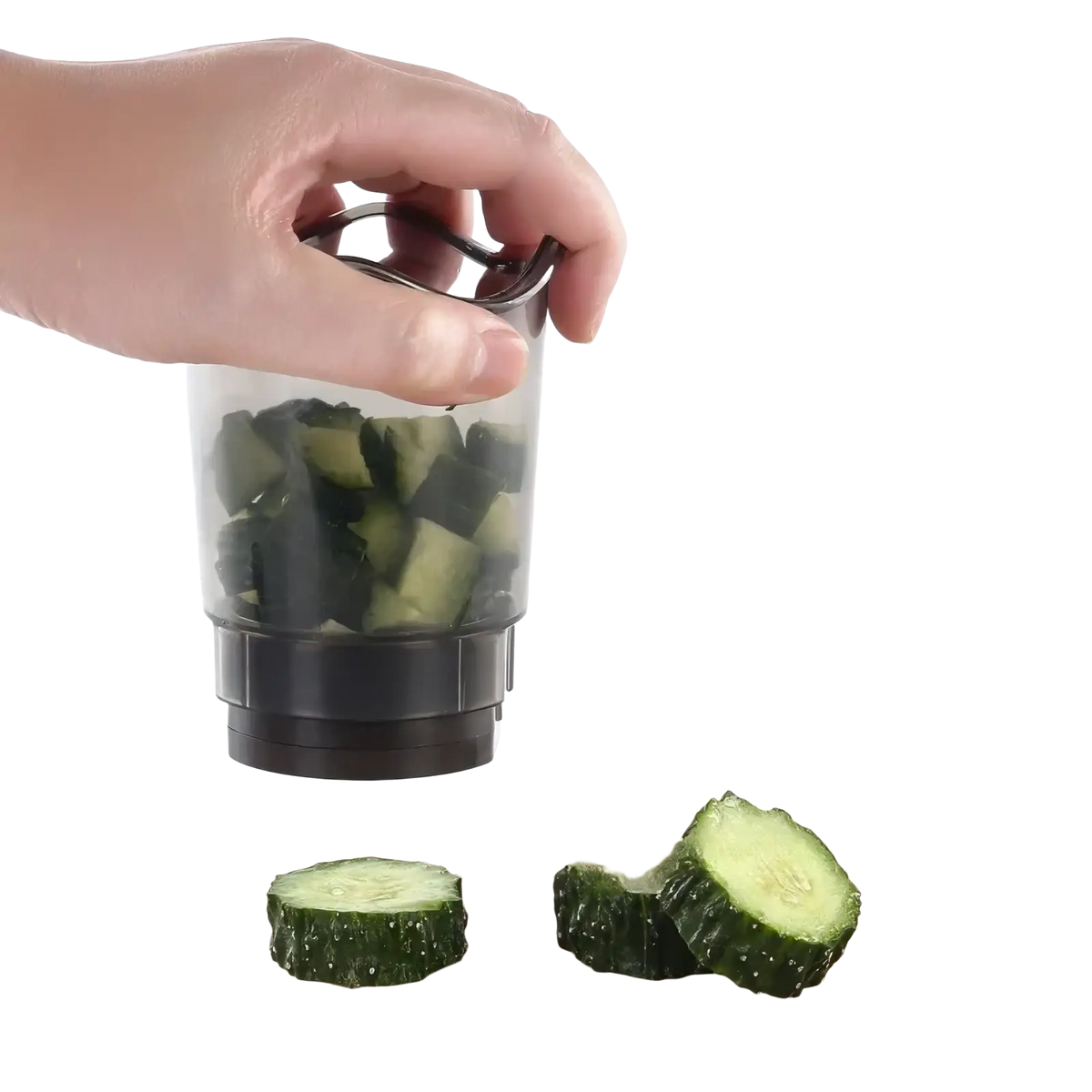 Handheld transparent plastic fruit and vegetable slicer with black base and handle filled with diced cucumbers