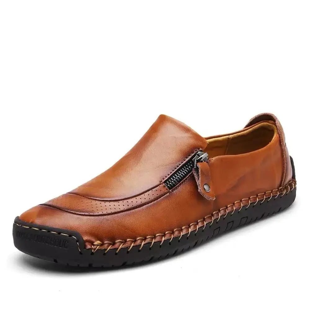 Men’s handcrafted tan leather slip-on loafer with zipper closure and visible stitching along the sole