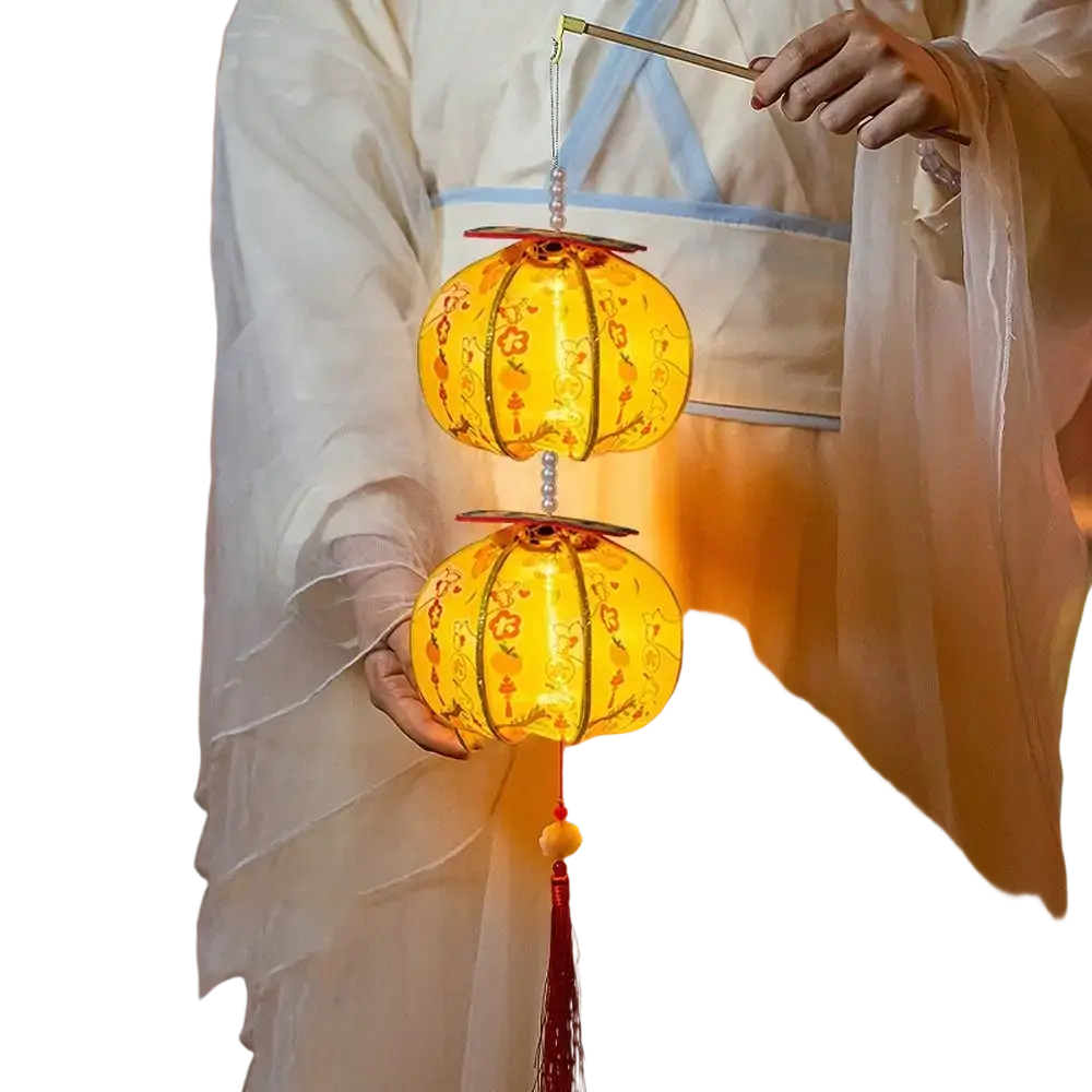 A handmade persimmon Chinese New Year lantern glowing yellow with intricate floral patterns and a red tassel hanging