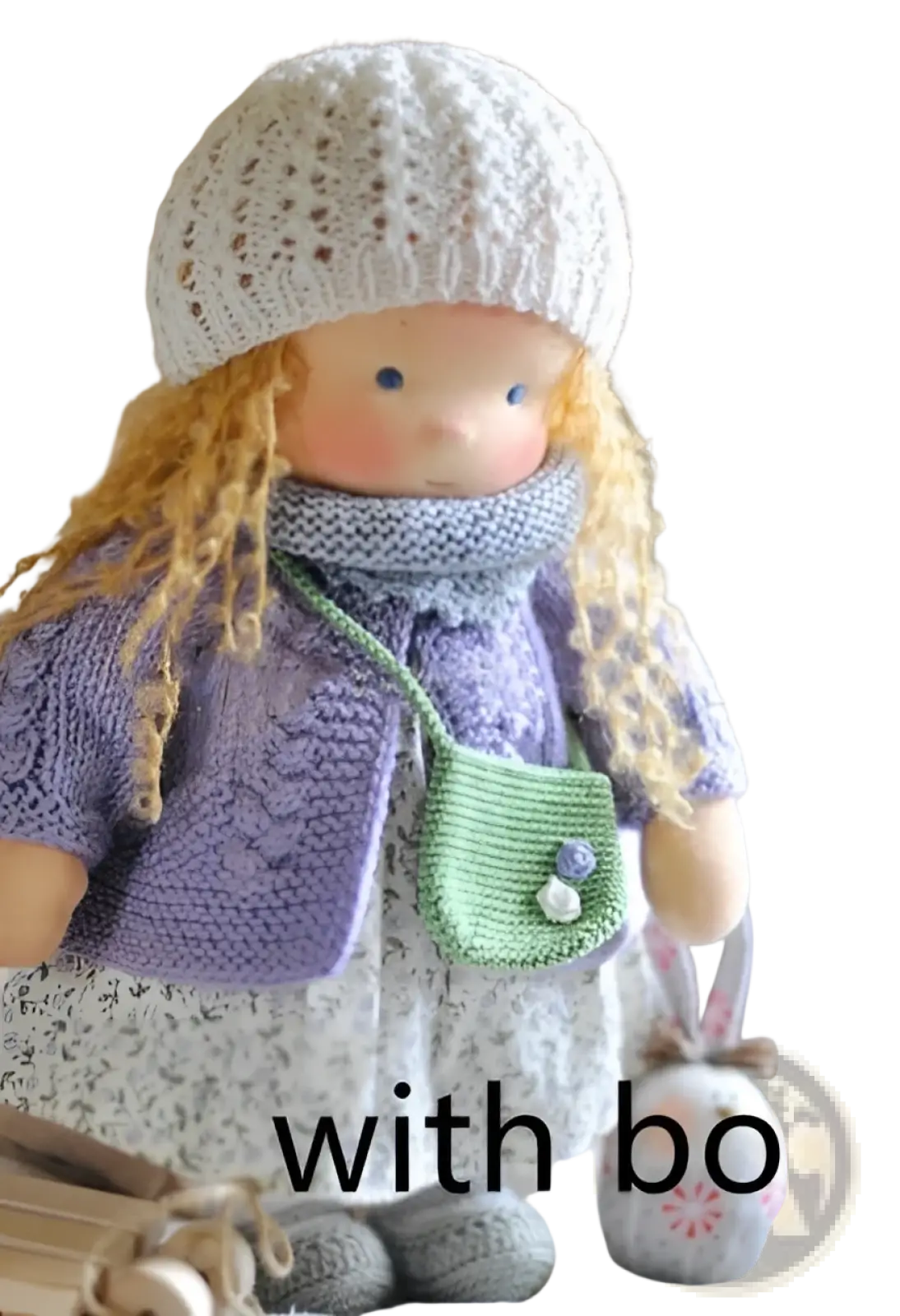 Handmade plush doll with golden curly hair wearing a white lace hat and purple knitted sweater carrying green purse