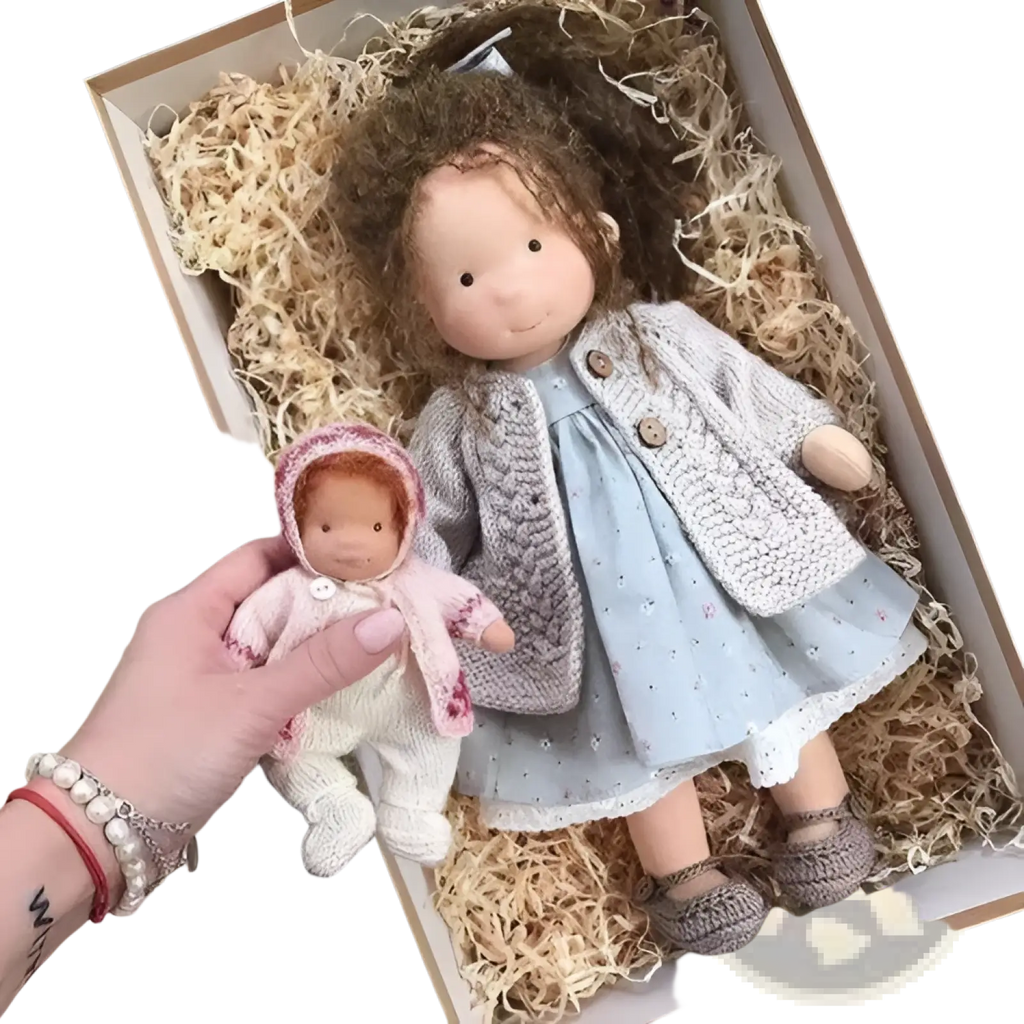 A hand holds a 30cm handmade plush doll with golden curly hair dressed in soft pink and white knitted floral attire