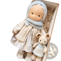 Handmade plush doll 30cm with golden curly hair wearing an off-white floral dress and blue knitted bonnet and scarf