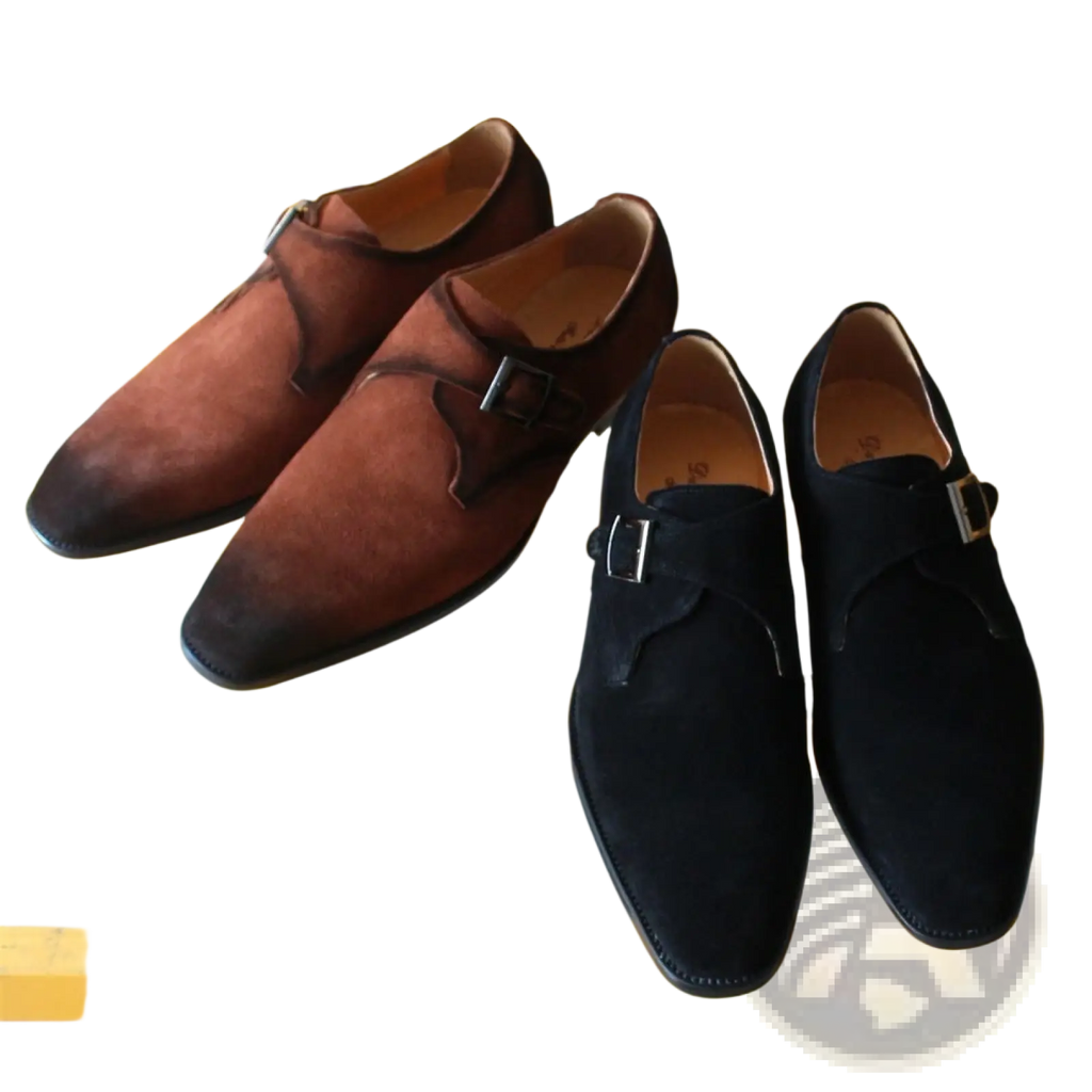 A pair of handmade brown suede monk strap shoes with black leather accents and silver buckles for business casual wear
