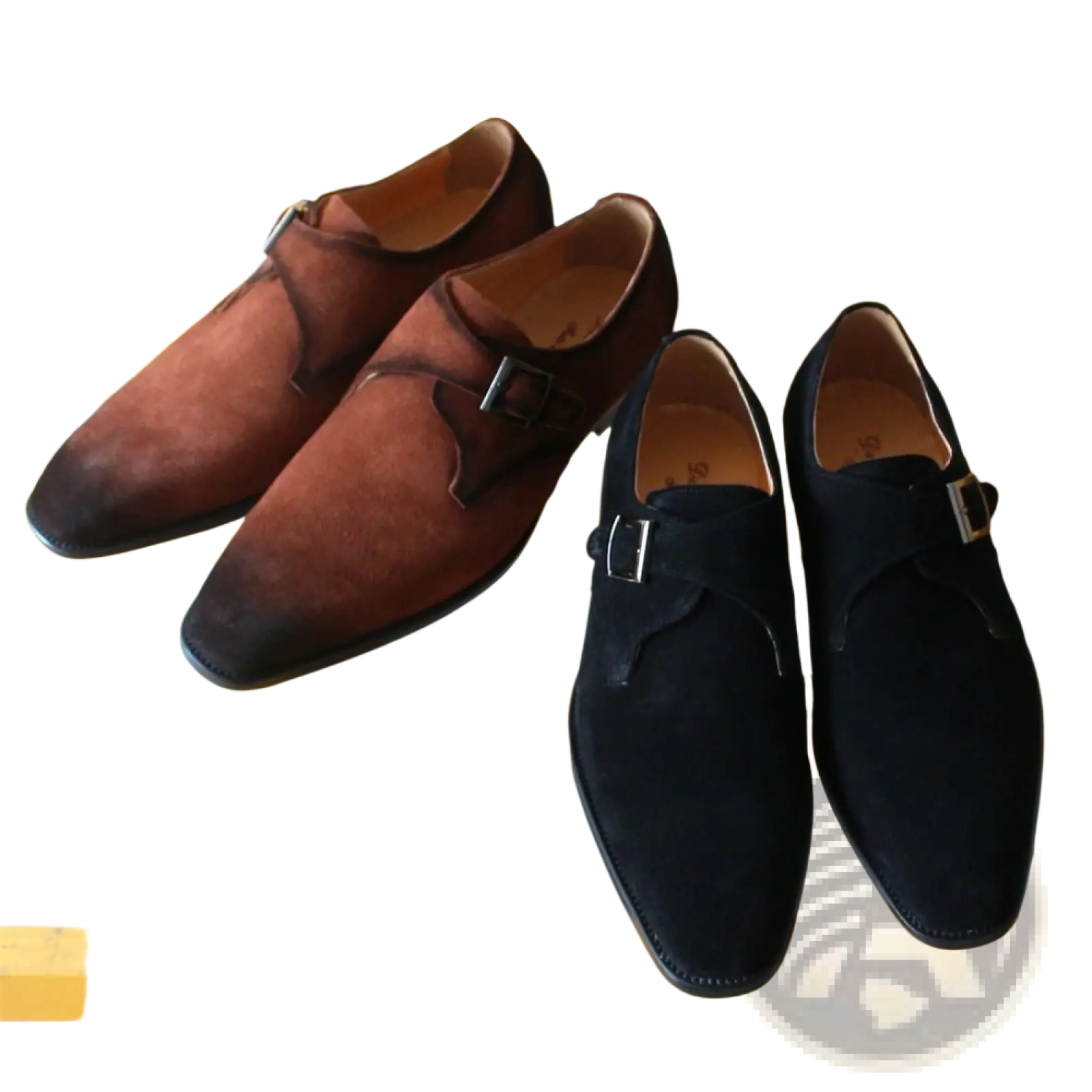 A pair of handmade brown suede monk strap shoes with black leather accents and silver buckles for business casual wear